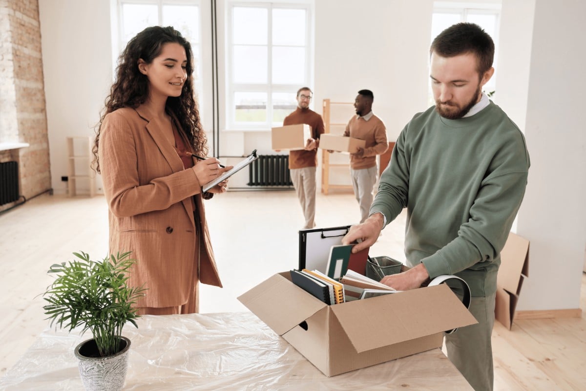A man and woman are packing boxes together in a room, preparing for a move or organizing items.