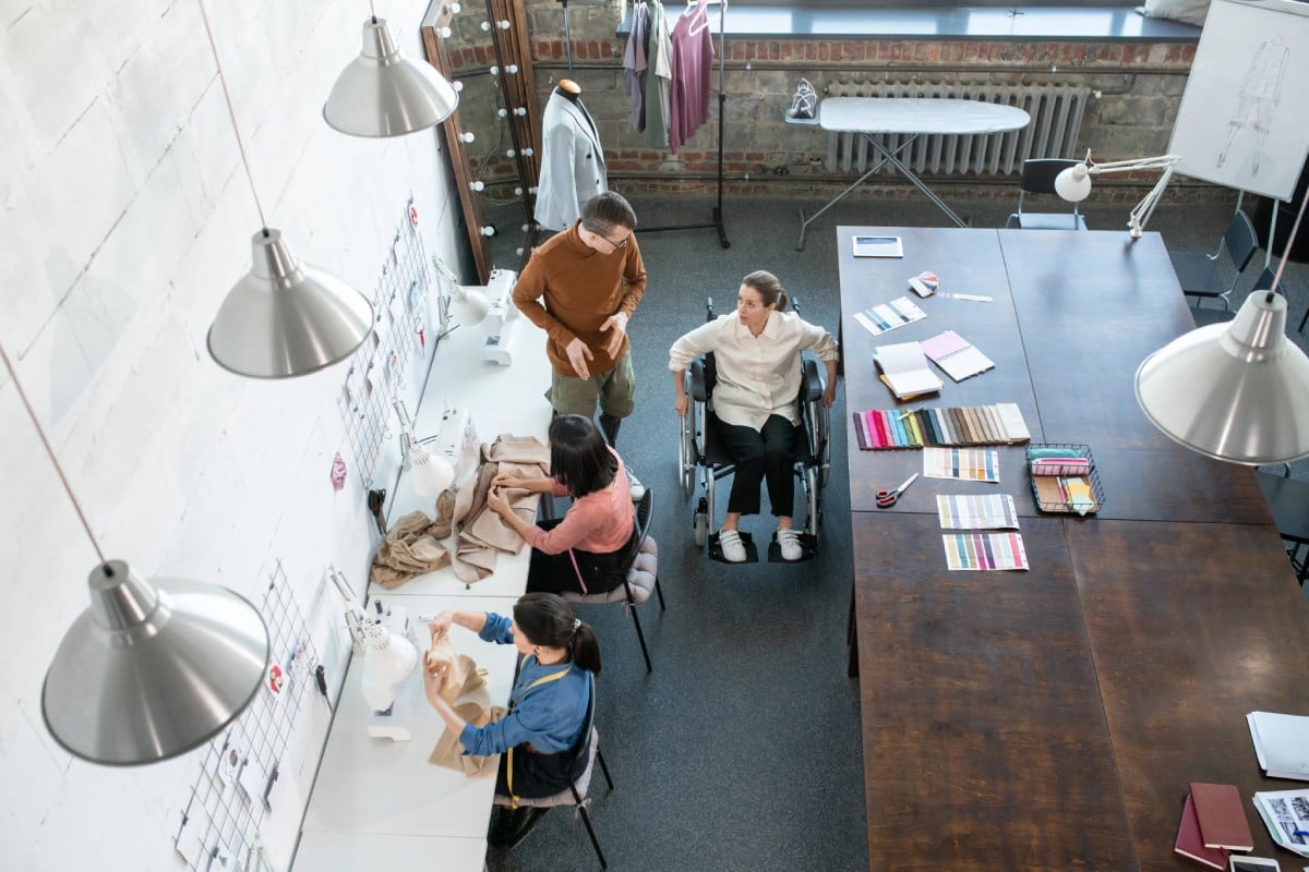 A diverse group of professionals seated around a conference table engaged in discussion in an office setting.