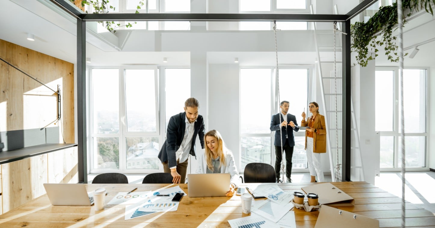 Business professionals collaborate in a modern office with a panoramic view of the city skyline.
