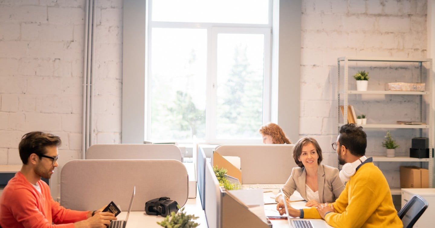 A diverse group of professionals collaborating in a modern office environment, focused on their tasks and discussions.