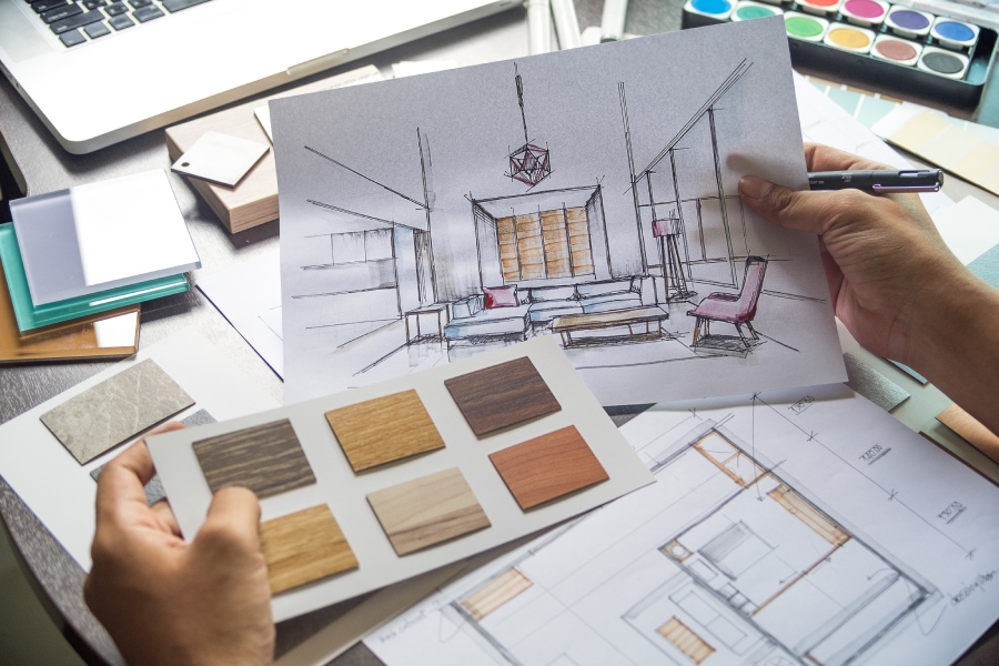 An individual is drawing a room layout on paper, showcasing their artistic process and attention to detail.